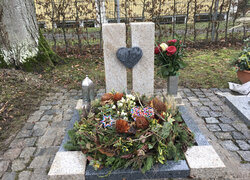 Stehender Stein hergestellt aus hellem Granit mit dunklen Herz in der Mitte, umrandet von einer Granit Einfassung, mit dunklen Rahmen und hellen Ecken | © Messerschmidt GmbH 