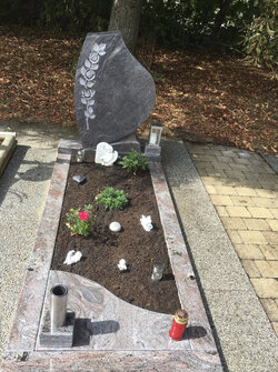 Stehender Grabstein für Einzelgrabstätte mit ausgearbeiteter Blume und Einfassung komplett aus Granit | © Messerschmidt GmbH