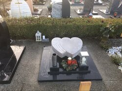 Liegender Doppelherzgrabstein aus Kalkstein mit Grabplatte aus Granit für eine Urnengrabstelle. | © Messerschmidt GmbH