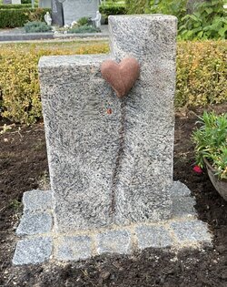 Stehender stein hergestellt aus grauem Granit mit rotem kleinen Herz  | © Messerschmidt GmbH