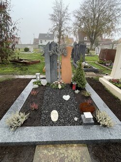 Stehender Stein hergestellt aus Sandstein und Diorit umrandet von einer dunklen Granit Einfassung mit Stahlbaum  | © Messerschmidt Gmbh