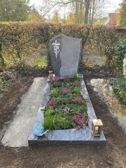 Stehender Grabstein für Einzelgrabstätte mit ausgearbeitetem Kreuz und Rosen und Einfassung gesamt aus Granit  | © Messerschmidt GmbH