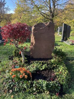 Stehender stein hergestellt aus rotem Sandstein mit rauer Oberfläche und kleinem eingravierten Kreuz  | © Messerschmidt GmbH