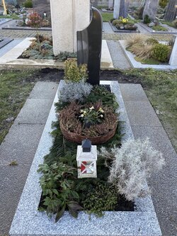 Stehender Stein hergestellt aus dunklem Granit umrandet von einer helleren Granit Einfassung  | © Messerschmidt GmbH