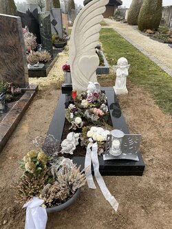 Stehender Stein hergestellt aus Kalkstein geformt als Engelsflügel und integrierten Herz umrandet von einer Einfassung aus dunklem Granit | © Messerschmidt GmbH 