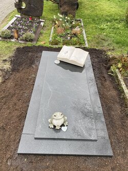 Liegender Einzelgrabstein in Buchform aus Kalkstein mit eingravierter Rose und Grabplatte aus Granit. | © Messerschmidt GmbH