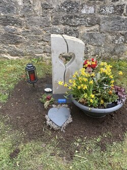 Stehender Urnengrabstein hergestellt aus Jura Kalkstein mit aus geschnittenem Herzen in der Mitte  | © Messerschmidt GmbH