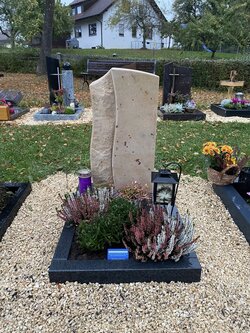 Stehender Grabstein angefertigt aus Sandstein für eine Urnengrabstelle mit Einfassung aus Diorit. | © Messerschmidt GmbH