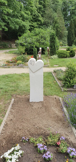 Ein stehender Grabstein aus Kalkstein gefertigt mit Herz und Tier Muster für ein Rasengrab gefertigt | © Messerschmidt