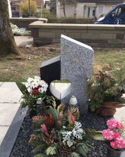 Stehender Stein hergestellt aus Basalt und hellem Granit mit Stahlrose am Stein und umrandet von einer Basalt Einfassung  | © Messerschmidt GmbH