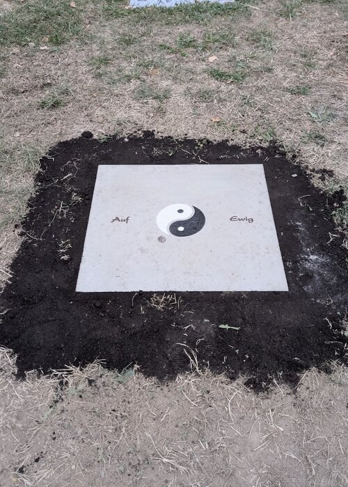 Platte für Rasengrab aus Jura Kalkstein bodeneben gesetzt. Vertieft eingearbeittes Symbol Yin und Yang schwarz und weiß gefäbrt. | © Messerschmidt GmbH