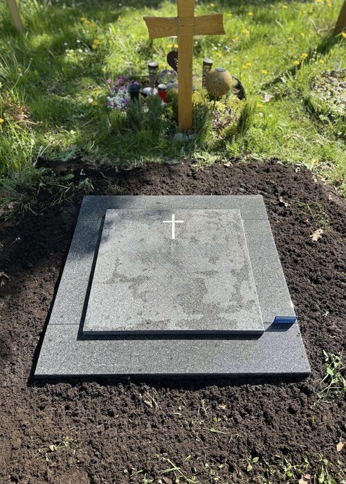Eine komplett mit dunklem Granit abgedeckte Urnengrabstelle. Die auf der Einfassung liegende Platte dient zur Beschriftung. | © Messerschmidt GmbH