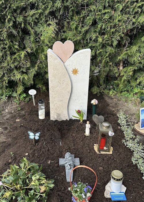 Urnengrabstein Modell Fremont. Angefertigt aus Jura Kalkstein mit Herz aus Sandstein. In den Stein ist eine Sonne vertieft eingearbeitet und farblich passend hinterlegt. | © Messerschmidt GmbH